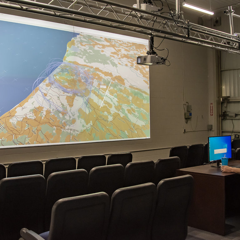 Photo of Steve Bigg, manager of the Advanced Aircraft Simulation Centre looking at screen in lecture theatre.