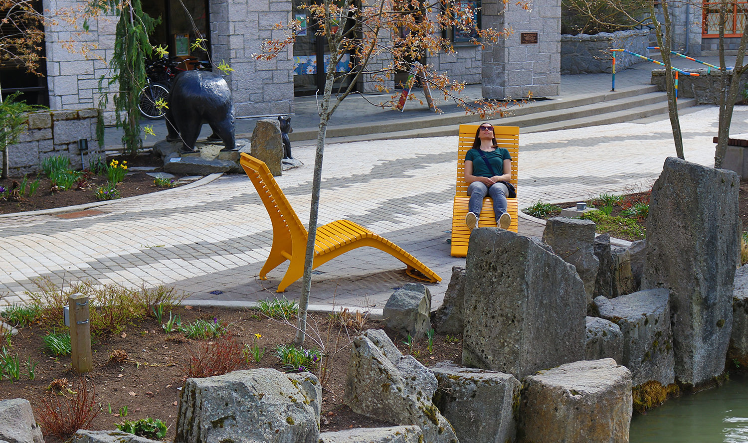 Women sitting on Yellow Chaise Lounge by rocks