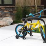 Yellow childrens bike on bike rack