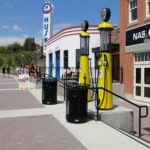 Two black waste bin before stairs leading downwards