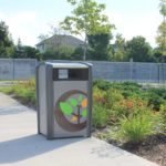Trash bin outside with gardens