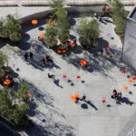 Looking down at Hudson Yards from the Vessel at brightly colored tables and chairs