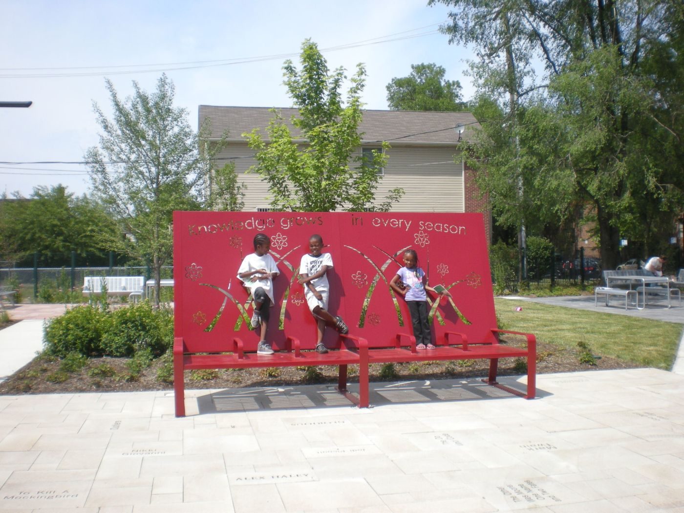 Three Children standing on Red Bench