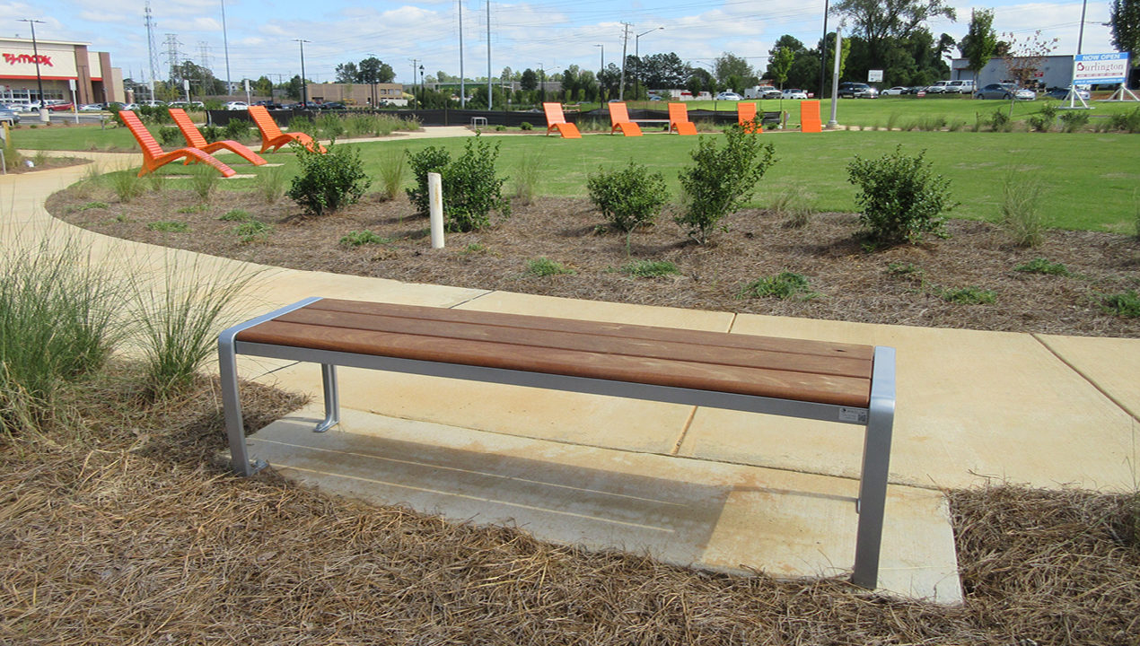 Backless Bench in green near orange lounge chairs