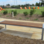 Backless Bench in green near orange lounge chairs