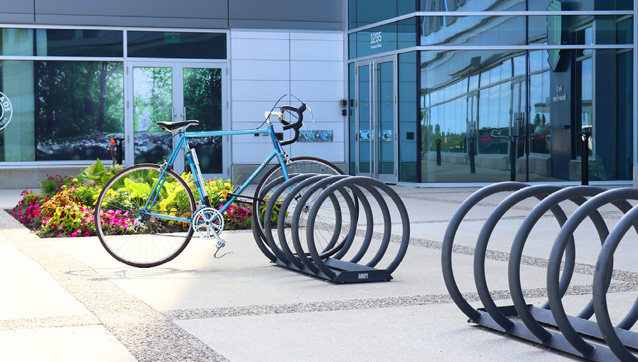 Grey Bike Rack with one bike outside of building