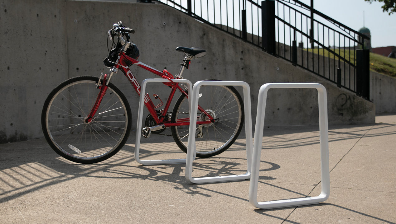White Bike Rack with Red Bike Leaning on it