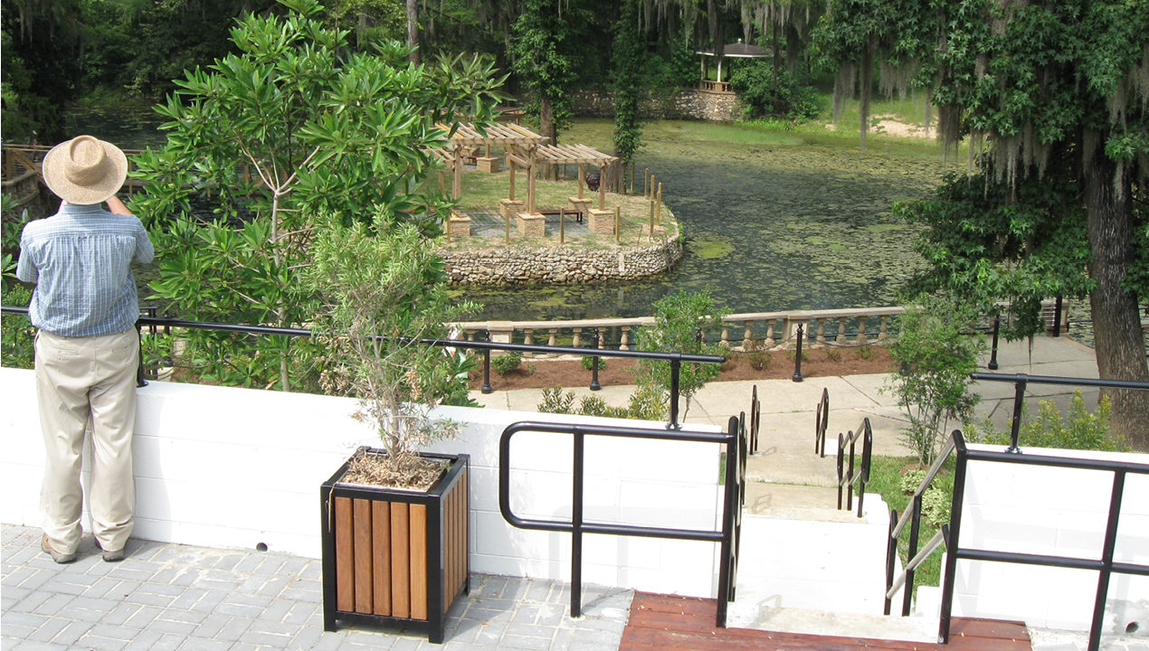 Man Overlooking Garden and Water Area
