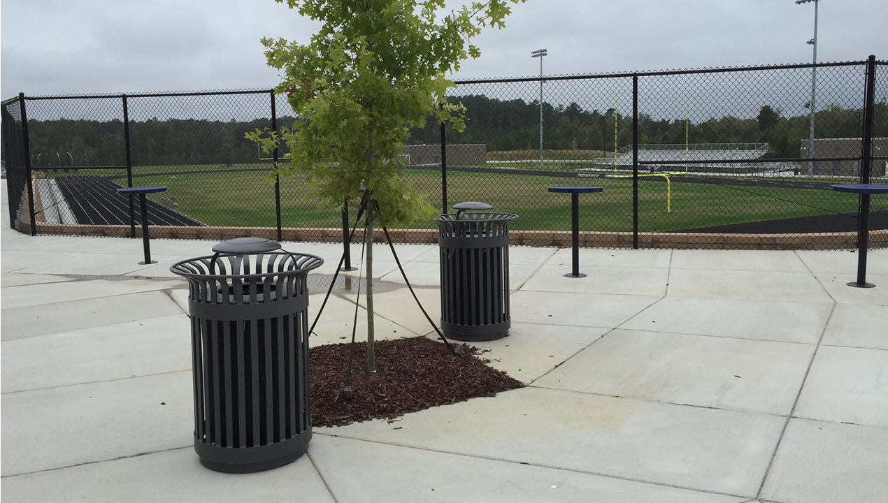 Two Trash Cans Outside a Sports Field