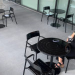 Black Foro tables and chairs with pretty girl having coffee