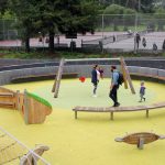 Overhead view of a playground with cantilever and pedestal mount backless wood Ogden benches and wooden playground equipment.