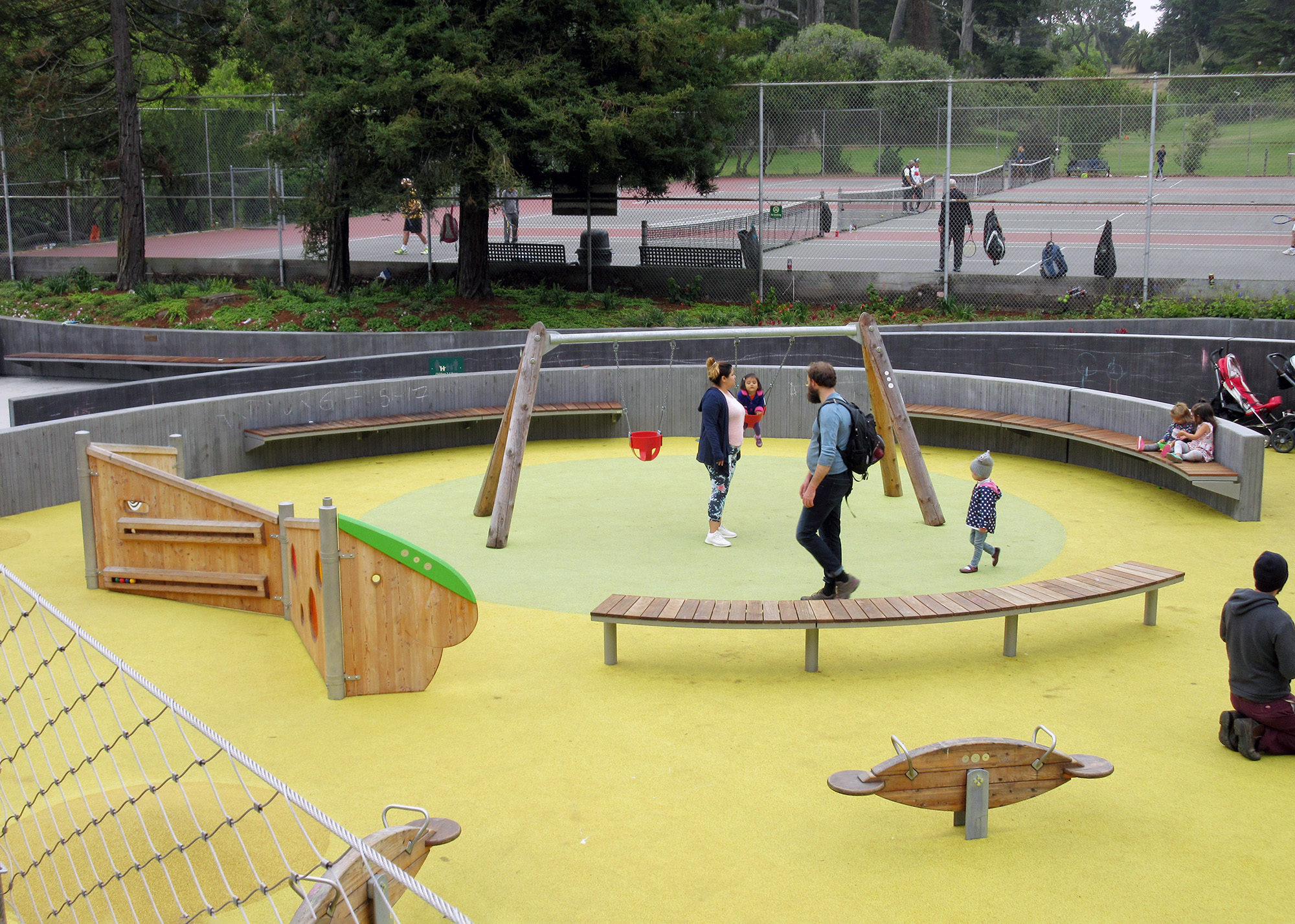 Overhead view of a playground with cantilever and pedestal mount backless wood Ogden benches and wooden playground equipment.