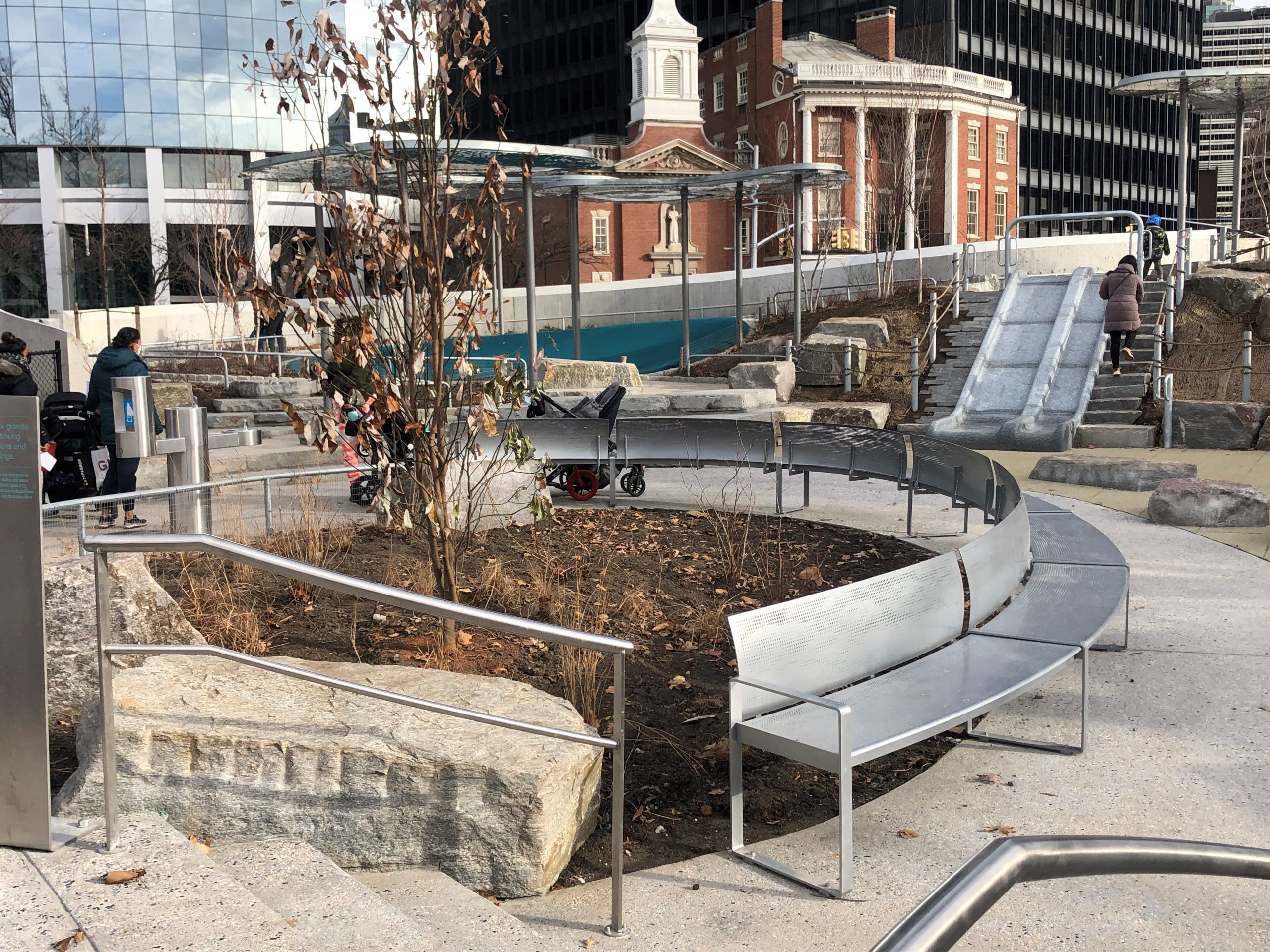 Custom curved steel perforated bench in the Battery Playscape