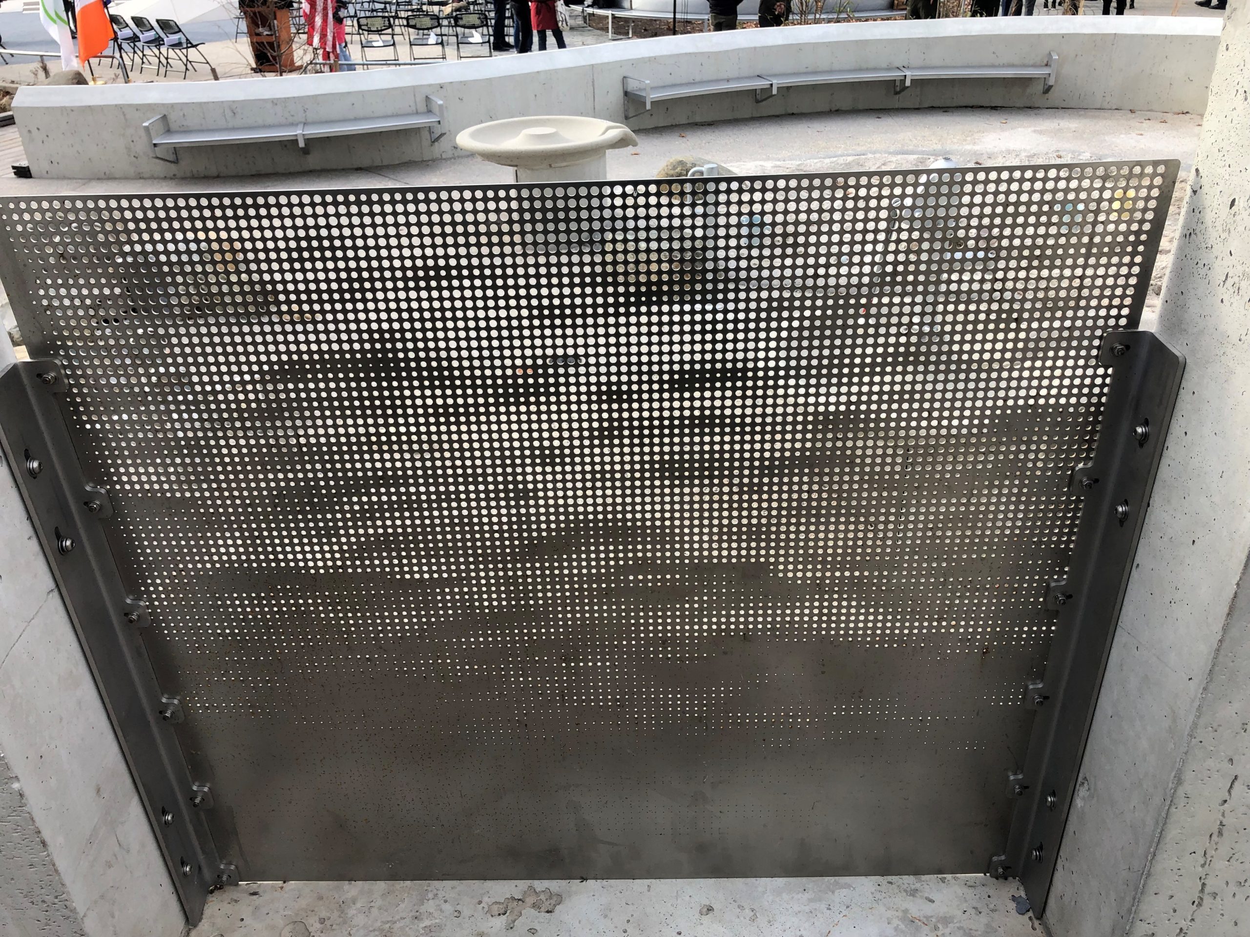 Close-up view of perforated metal screen with a pattern of clouds.