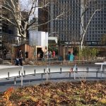 Back of custom perforated bench in foreground in front of playground