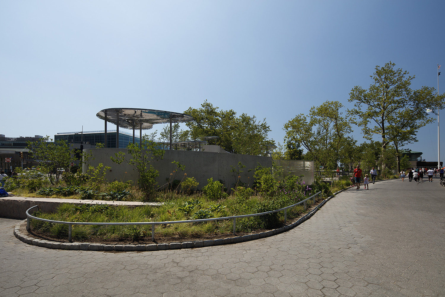 Paved pathway next to Battery Playscape with custom perforated metal shade structures in the background
