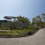 Paved pathway next to Battery Playscape with custom perforated metal shade structures in the background