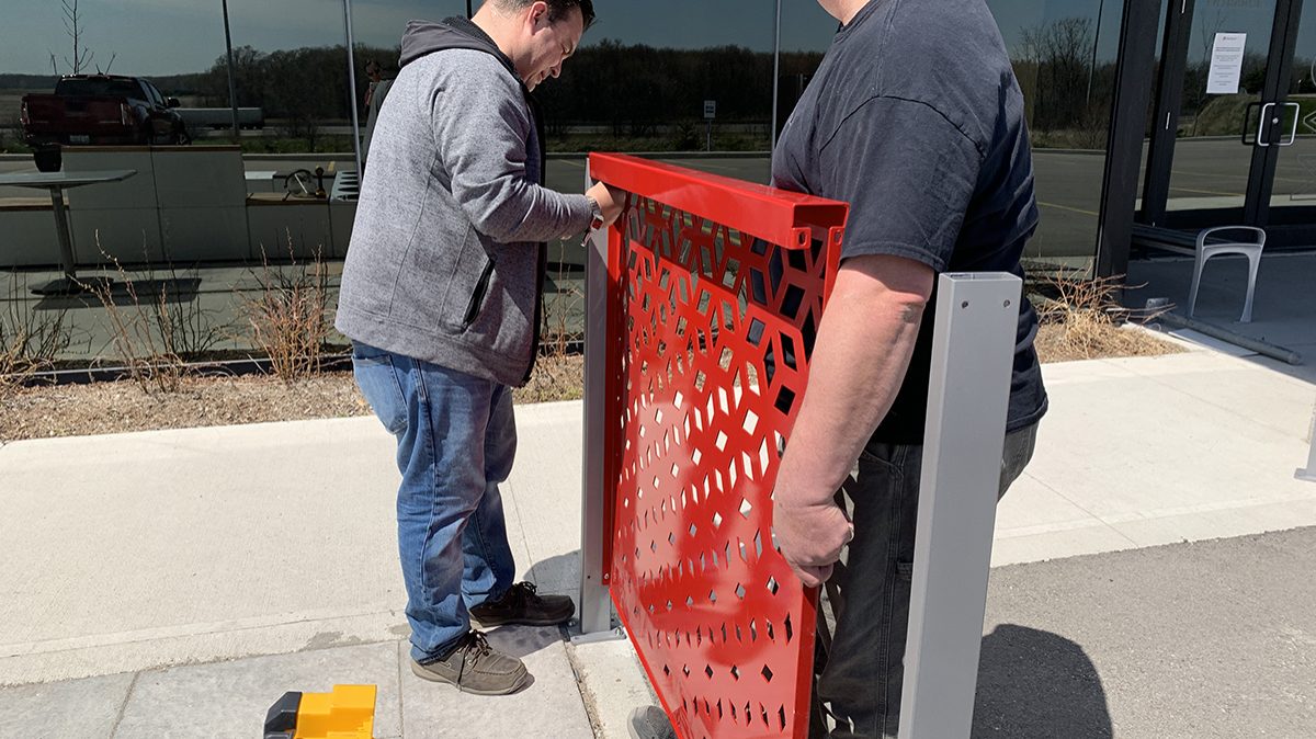 red-flexx-installation-mike-rodney Two men work together to install a Maglin FLEXX panel on a concrete surface.