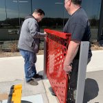 Two men work together to install a Maglin FLEXX panel on a concrete surface.