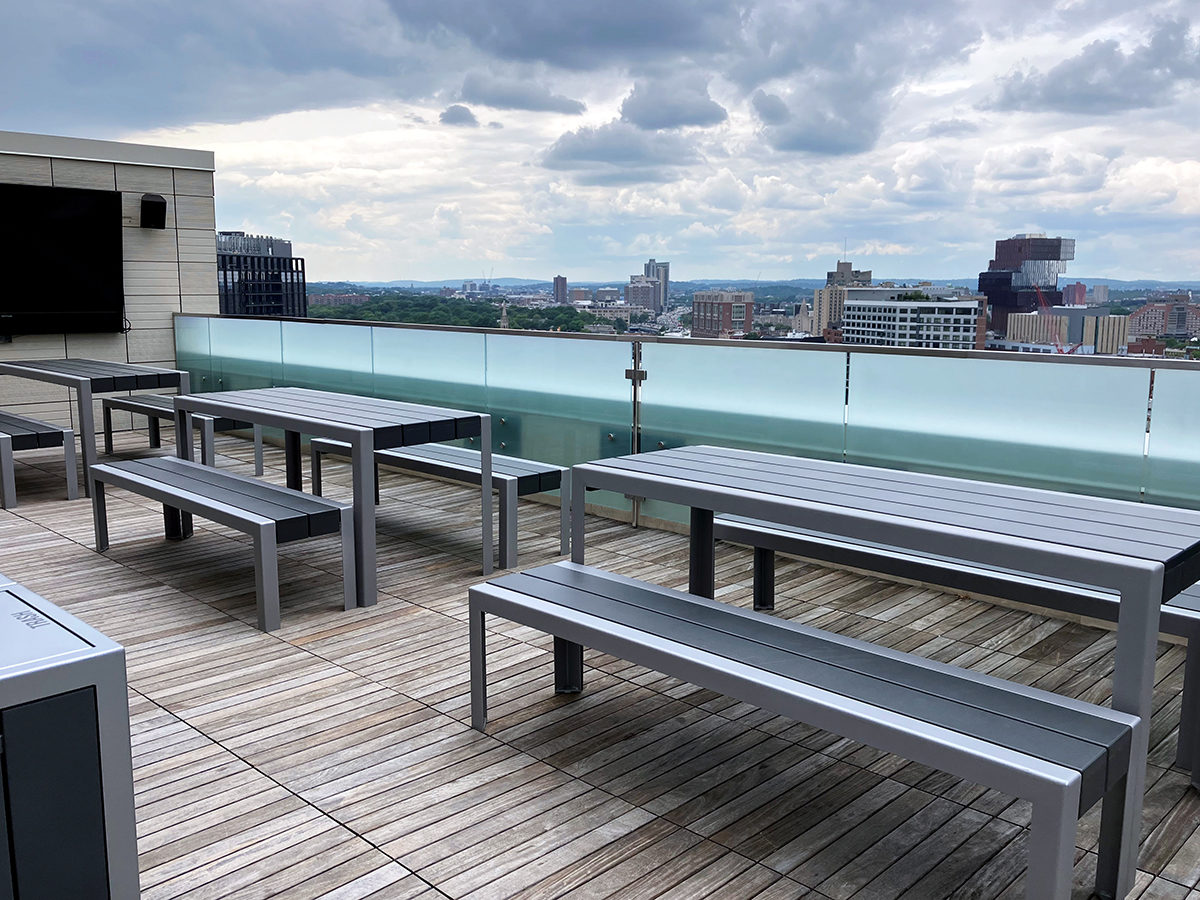 Three sets of 1050 tables and benches are lined up on the roof deck of Viridian Apartments.