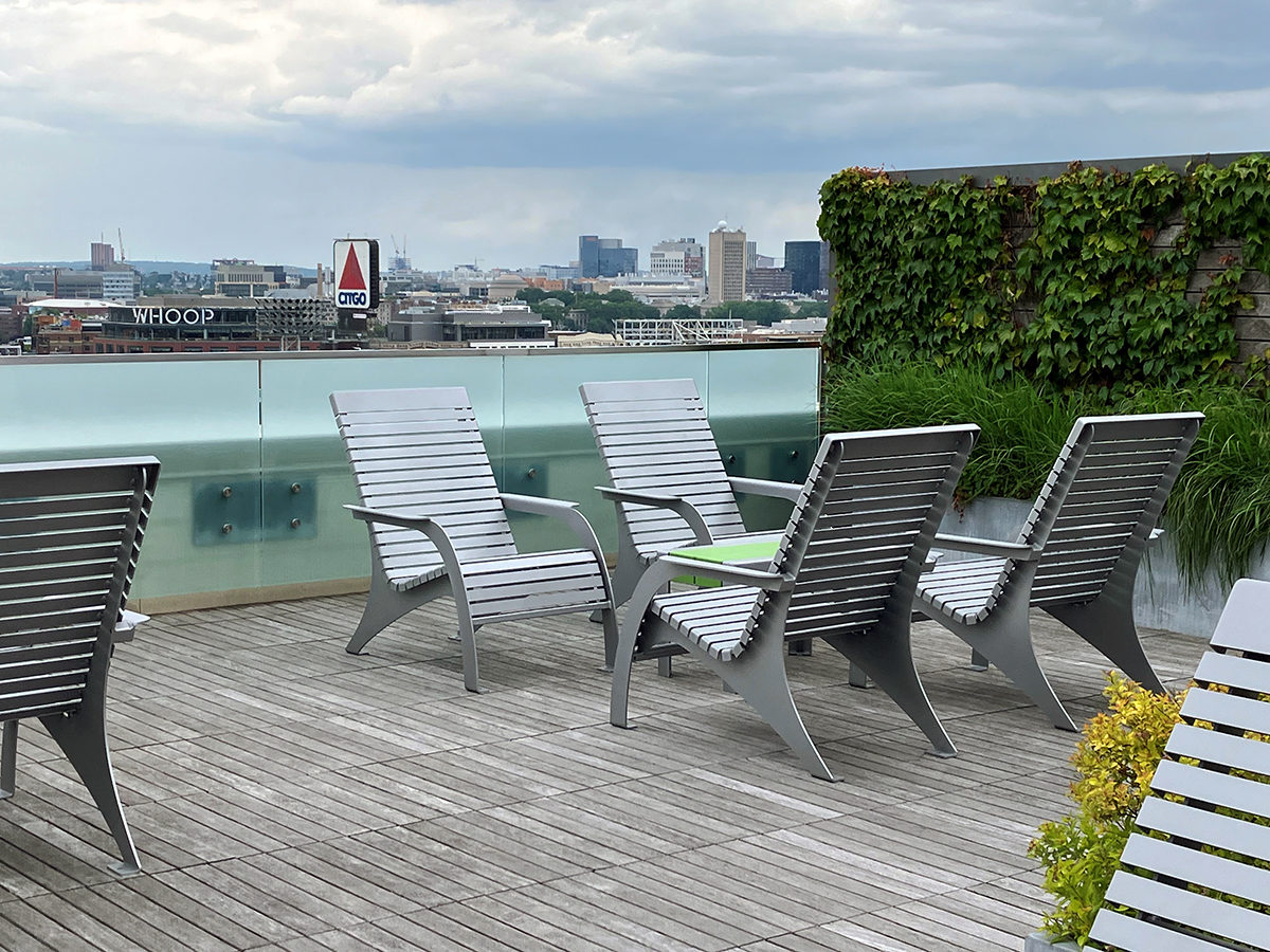 A group of four 720 chairs face each other with a 1050 short bench as a cocktail table on the roof deck of Viridian Apartments.
