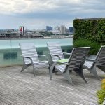 A group of four 720 chairs face each other with a 1050 short bench as a cocktail table on the roof deck of Viridian Apartments.