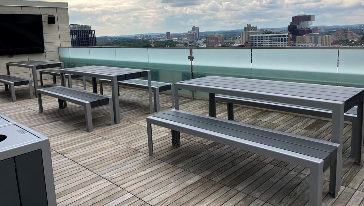 1050 Standard Tables with Backless Benches on rooftop patio overlooking city