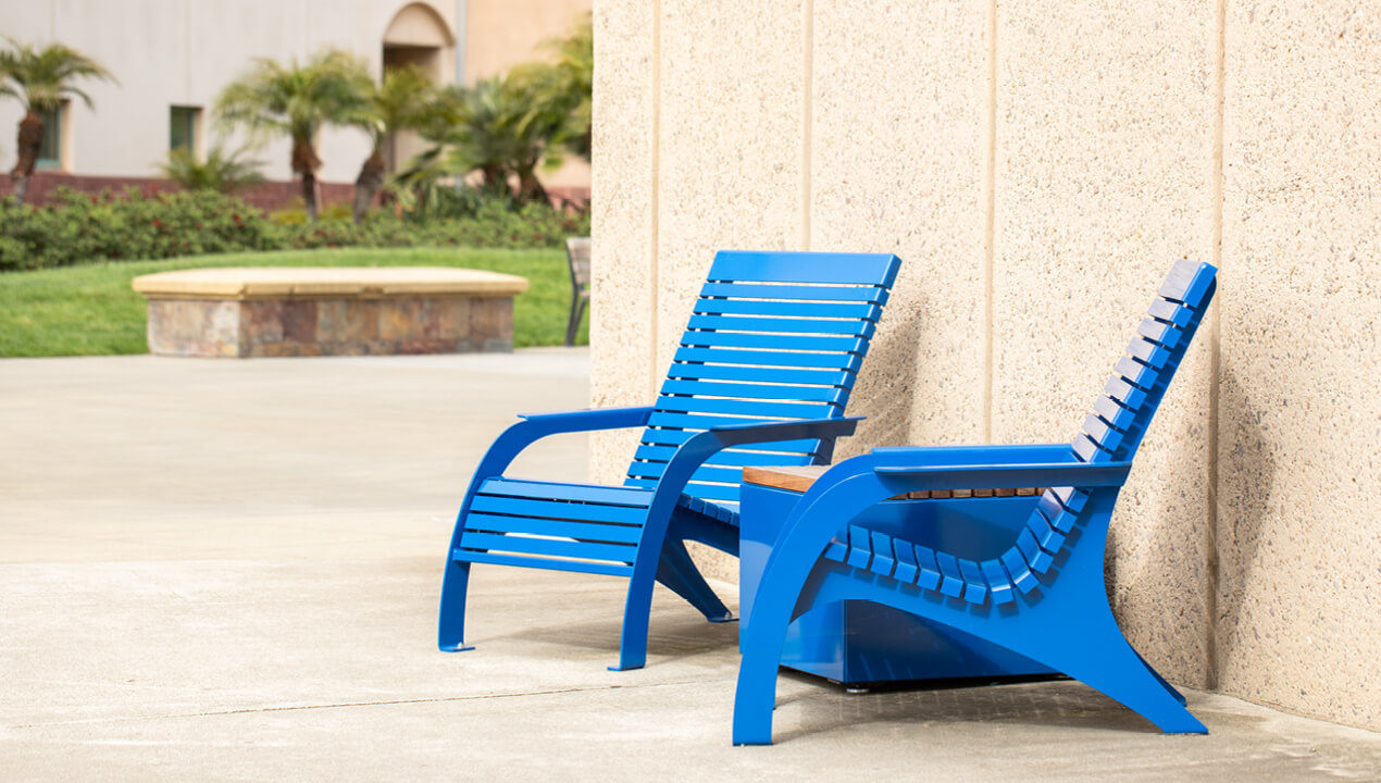 Brightly painted blue 720 Chairs with Pixel block on school campus against wall