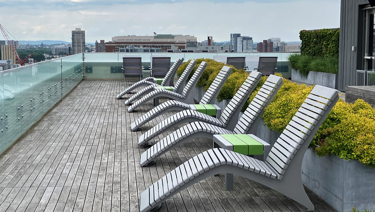 720 Metal Chaise Lounge on rooftop deck surrounded by city buildings