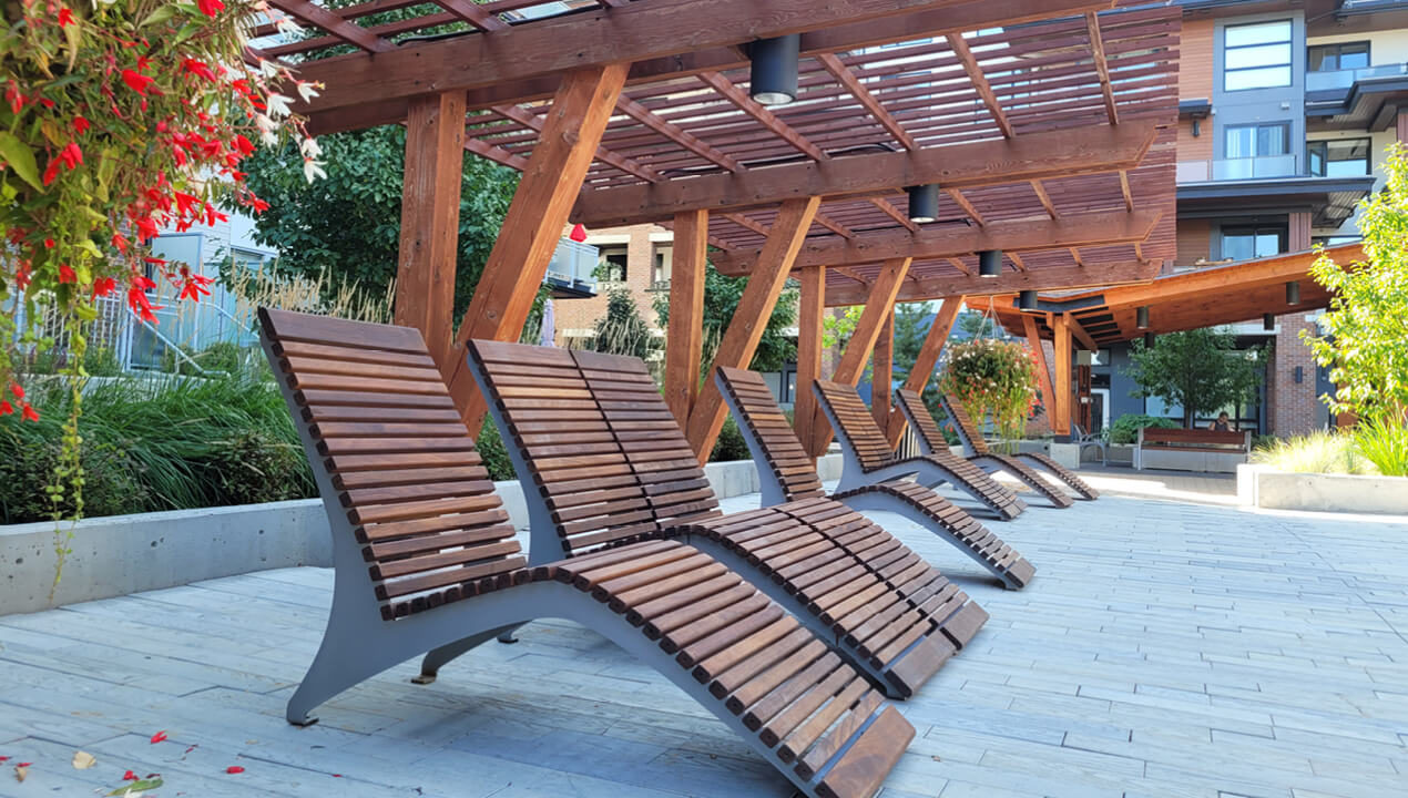 720 Chair Lounge in Ipe Wood under wooden pergola surrounded by trees and bushes