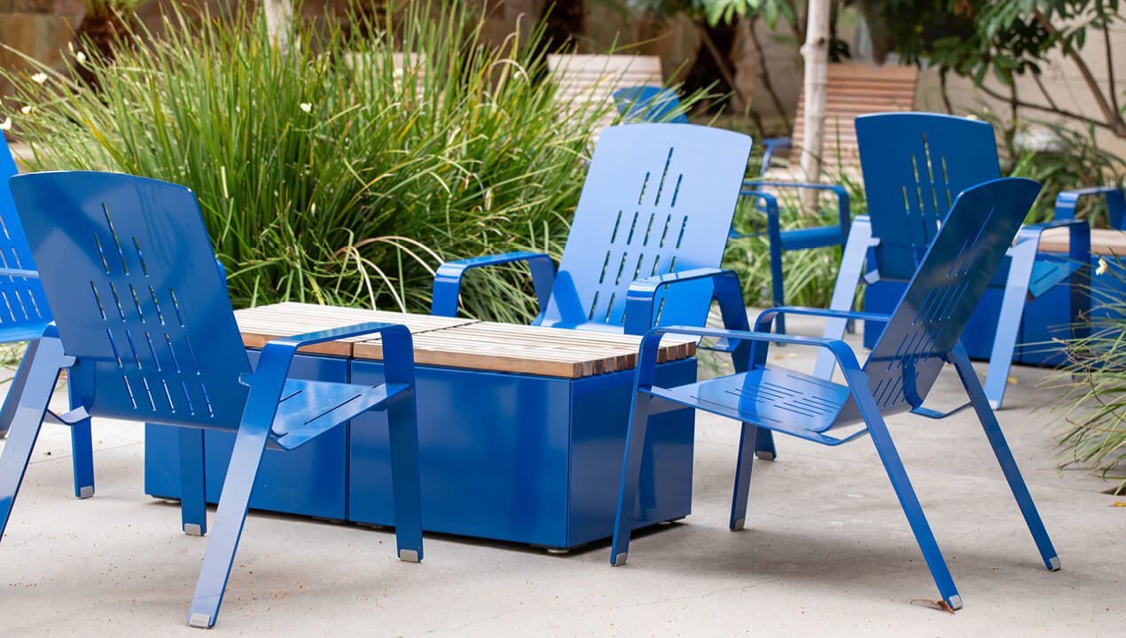 maglin-alum-lounge_blue ALUM Lounge Chairs painted gloss blue with Pixel table blocks on a patio with greenery