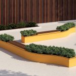 CANOE modular planters with seating in bright yellow powdercoat against wooden wall