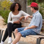 Backed Iconic Bench with a man and woman chatting against a blurred background