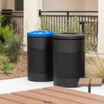 Maglin 600 Series black Recycling and Waste containers are placed in the amenity courtyard of an apartment in Chula Vista, CA. The recycling container has a blue lid to denote its purpose.