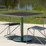 Foro table with thermally modified ash wood top and kontur chairs next to greenery and lake