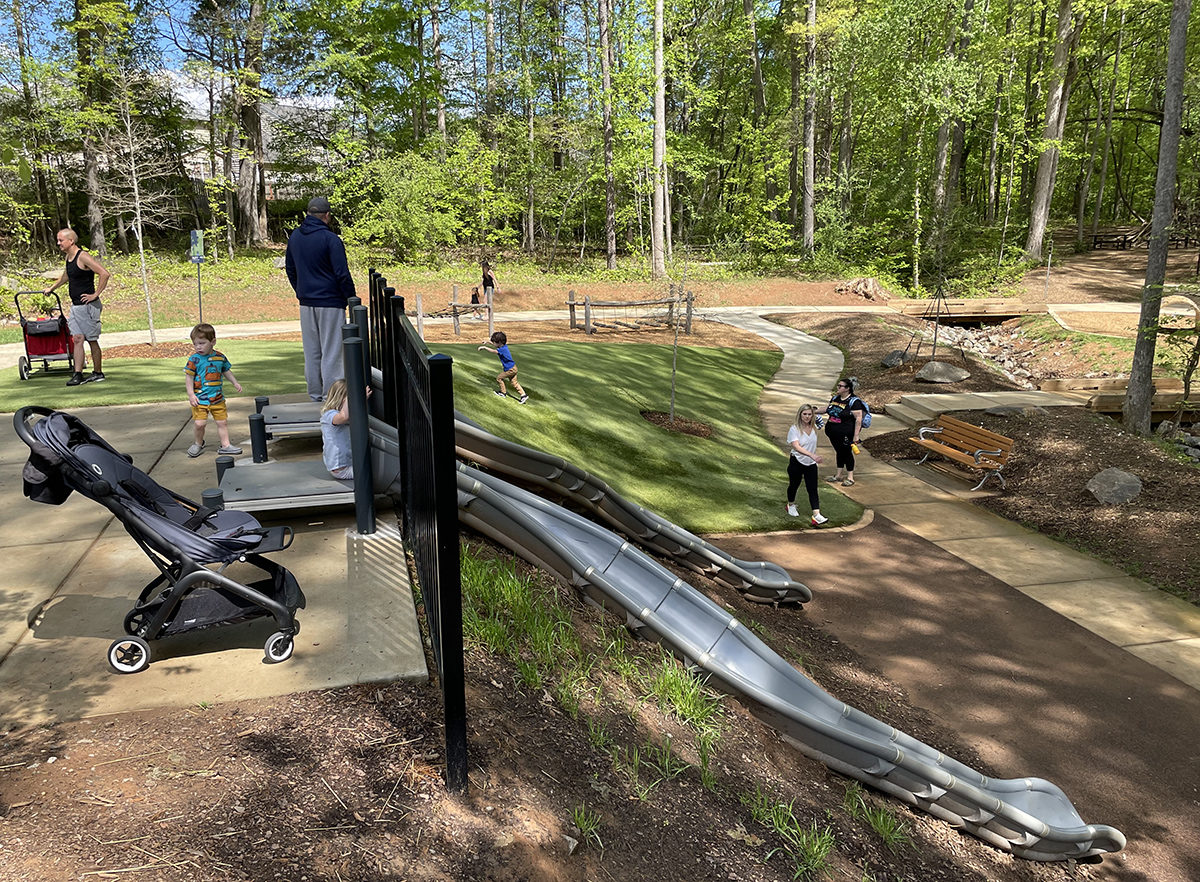 Les enfants attendent de glisser sur deux toboggans à flanc de colline au parc naturel de Rosedale à Huntersville, en Caroline du Nord.