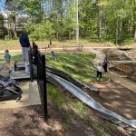 Les enfants attendent de glisser sur deux toboggans à flanc de colline au parc naturel de Rosedale à Huntersville, en Caroline du Nord.
