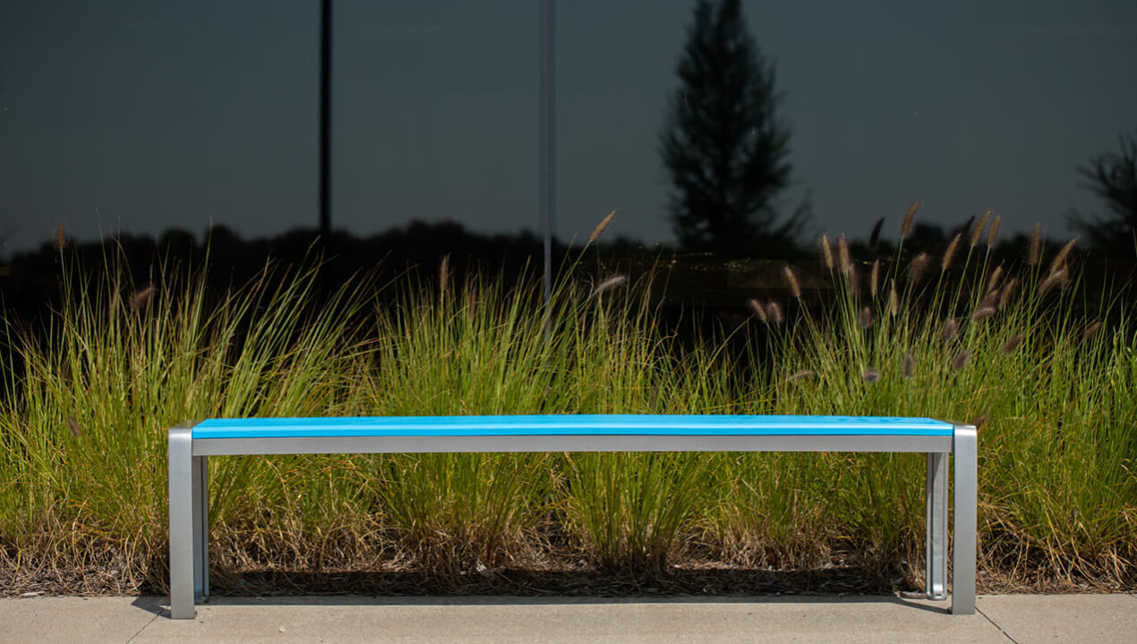 970 Backless Bench with High Density Polyethylene Seat in Blue with grasses in background