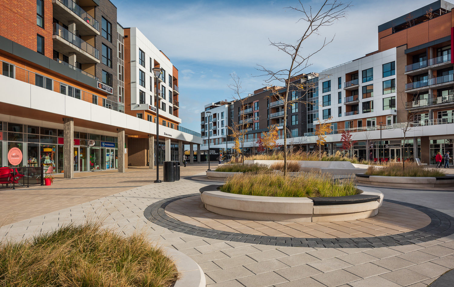 agora-ogden-backless-wallmount-hdpc-650-trash Several raised circular concrete planting beds offer seating with Ogden Benches wallmounted on top.