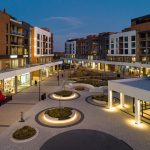 A nighttime top view of the lighting in AGORA Plaza, featuring Ogden Wall-mount benches and several Maglin 650 Waste and Recycling Containers.