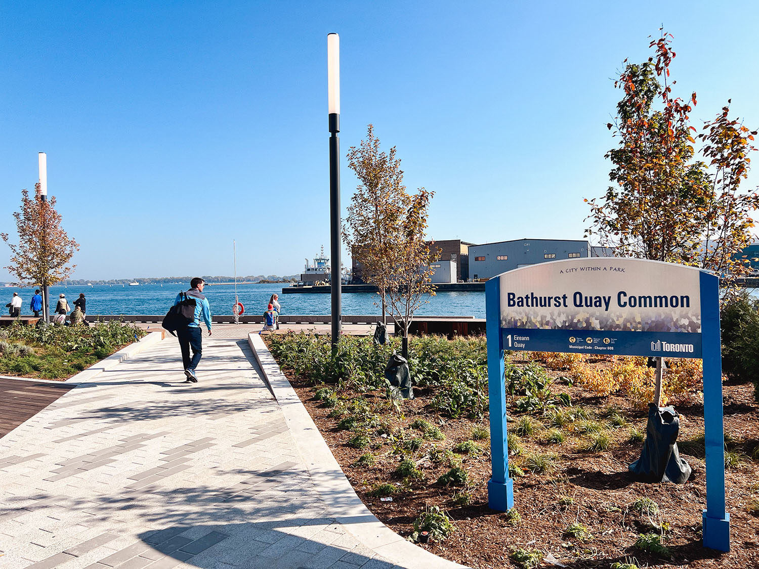The sign at Bathurst Quay Common in Toronto with Lake Ontario in the background.