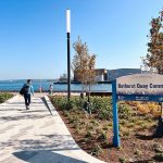 The sign at Bathurst Quay Common in Toronto with Lake Ontario in the background.