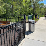 Rosedale Nature Park surrounding by lush trees and a pathway leading to the park with Maglin's benches and trash containers