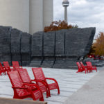 The CN Tower in Toronto overlooks Bathurst Quay Commons and red Maglin 720 Chairs