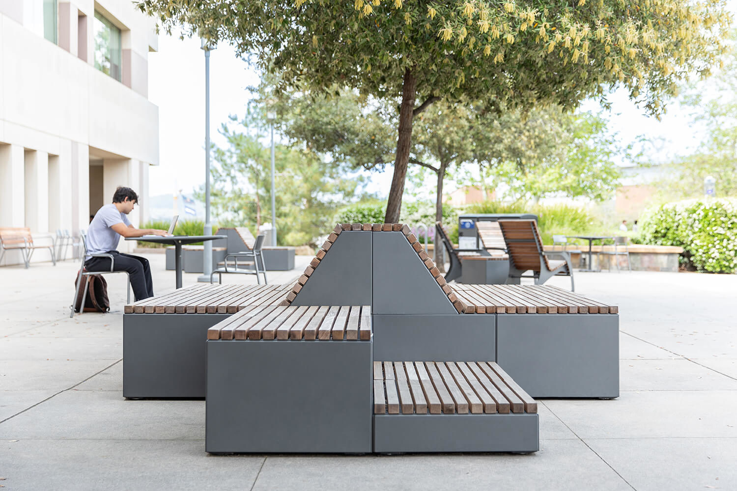 Maglin Pixel Blocks configured to allow seating on a patio with a student studying in the background at CSUSM
