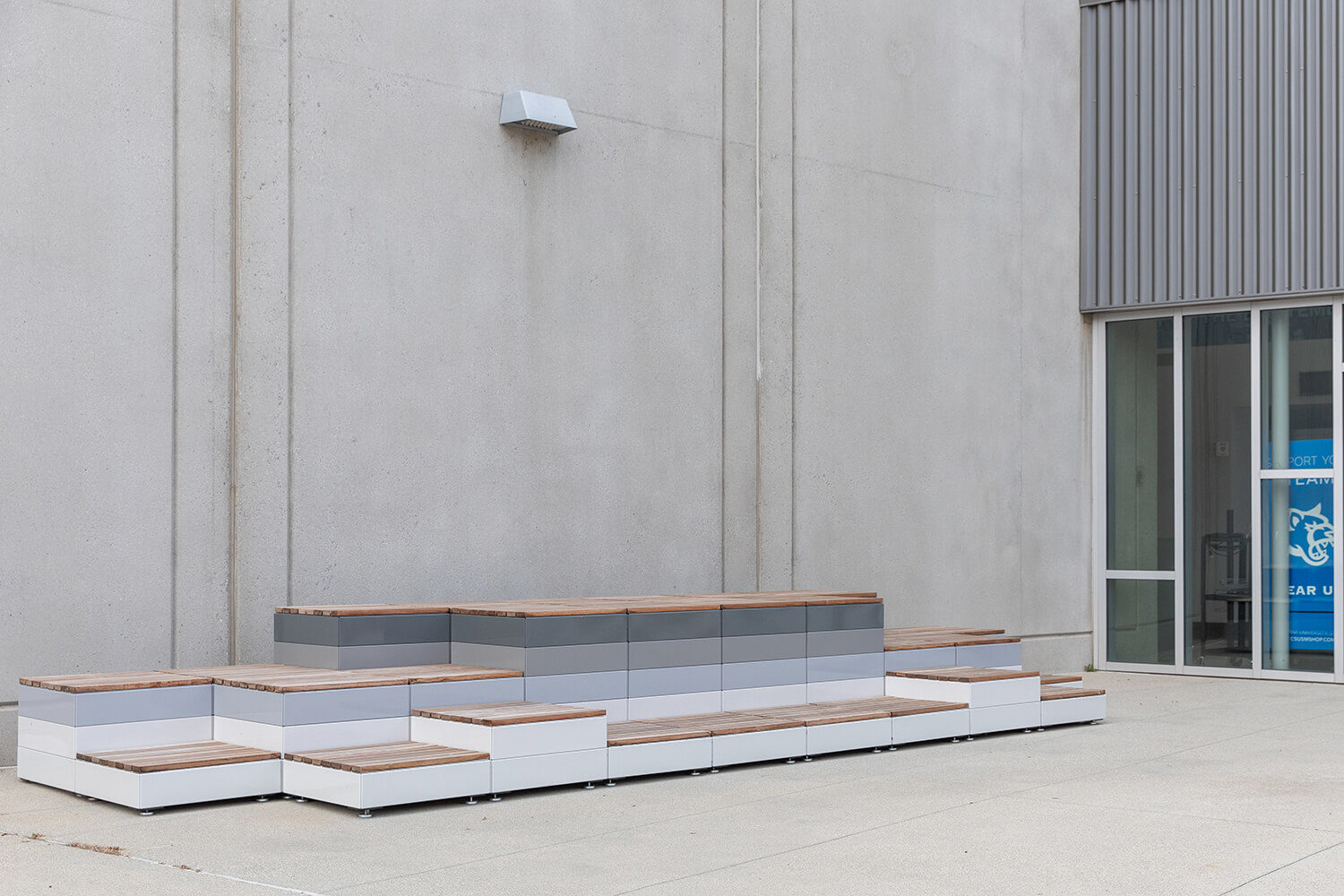 Maglin Pixel Blocks painted in light to dark gradient with short blocks stacked outside a building at CSUSM