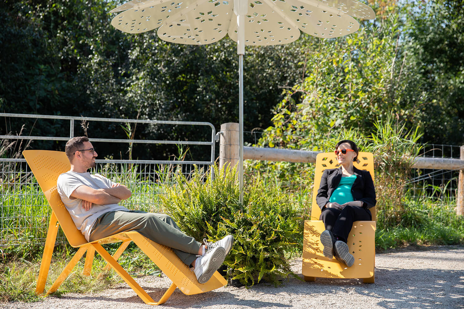Maglin employees enjoying the fresh air while relaxing on ALUM chaise lounge's under ROMA umbrella shade