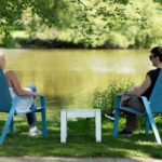 Maglin employees relaxing by the water while sitting in ALUM lounge chairs