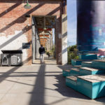 Man walking away from Maglin Pixel blocks and Lexicon waste and recycling at Camp North End