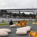 720 Maglin chairs overlooking waterfront with bridge in background and two men chatting